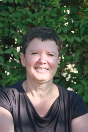 Portrait Daniela Budnowski Portrait von Daniela Budnowski im Grünen – freundliches Lächeln vor natürlichem, ruhigem Hintergrund