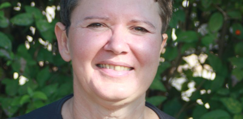 Portrait von Daniela Budnowski im Grünen – freundliches Lächeln vor natürlichem, ruhigem Hintergrund