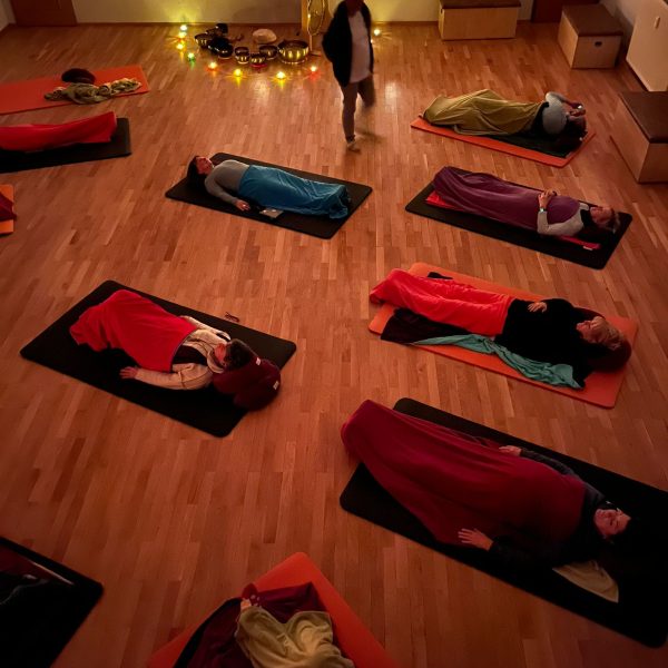 Teilnehmende liegen auf Yogamatten und erleben ein Klangbad in Neuzelle – Vogelperspektive, tiefe Entspannung durch Klangschalen