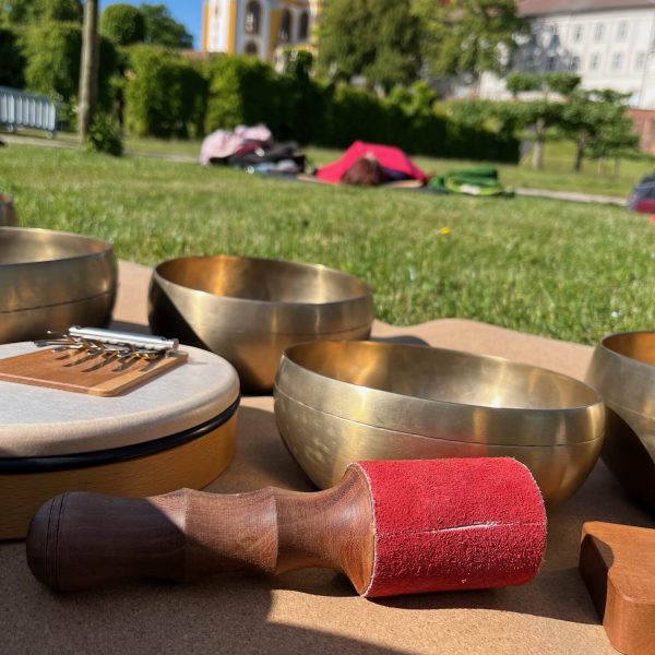 Klangequipment mit Klangschalen und Matte im Klostergarten für eine meditative Klangyogastunde