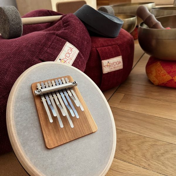 Yogaequipment mit Klangschale, Yogamatte, Bolster und Meditationskissen für eine Yogastunde mit Klang